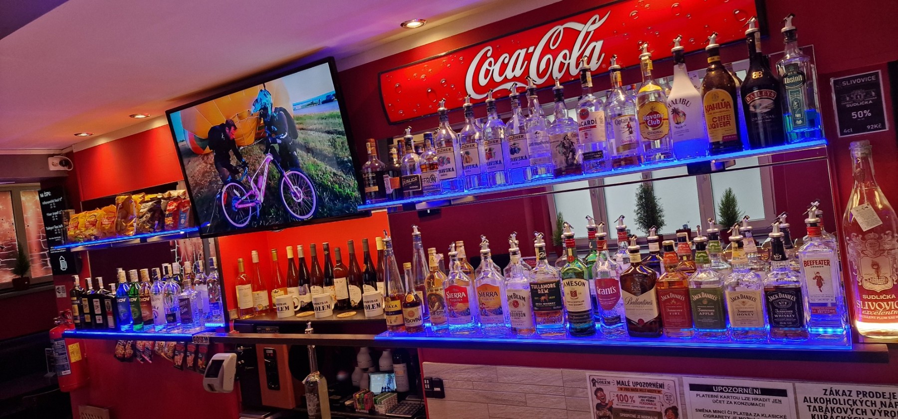 Výběr lahví alkoholických nápojů za barem GOLEM